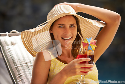 Image of Woman, cocktail and drink by swimming pool on lounge chair for summer, holiday and tropical vacation. Young person or tourist in portrait by hotel with hat, glass or alcohol for happy, outdoor break