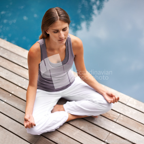 Image of Woman, yoga and meditation by swimming pool for wellness, health and care on holiday or vacation. Calm, young person with lotus pose for spiritual, holistic and breathing exercise outdoor or on deck