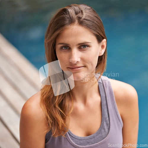 Image of Portrait, woman and swimming pool for holiday, vacation and outdoor with wellness and fitness. Face of a young person relaxing by water for summer, exercise or workout by a hotel or luxury home