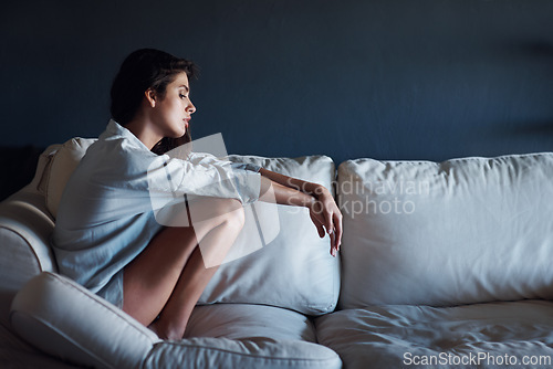 Image of Depression, sad and woman relaxing on sofa in living room for loneliness at modern house. Mental health, upset and unhappy young female person sitting, resting and thinking on couch at apartment.