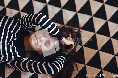 Image of Woman, lying and carpet for fashion, interior design and decor as abstract, pattern and aesthetic. Female person, stylish and trendy on monochrome, luxury and rug in designer couture in home makeover