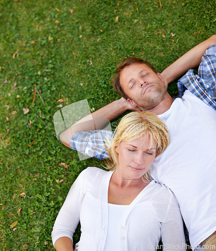 Image of Love, sleeping and couple in nature with peace, relax or top view chilling on holiday, vacation or resting outdoor. Calm, above or people lying in grass for sleep, nap or snooze on countryside trip