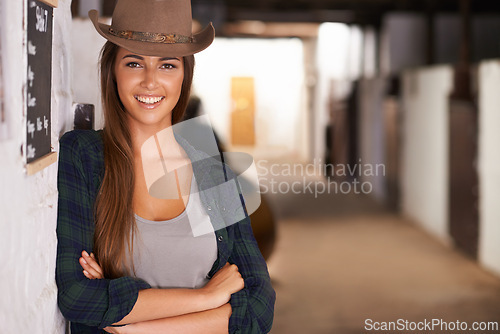 Image of Cowgirl or woman, confident and portrait in barn in rural or countryside for agriculture and summer adventure. Female cowboy or equestrian in stable or ranch with arms crossed in Western Texas.