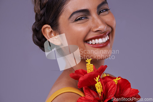 Image of Studio, woman and portrait with flower for makeup, cosmetics and floral beauty with smile. Happy, Indian person and face with dermatology for luxury, wellness and sustainability on purple background