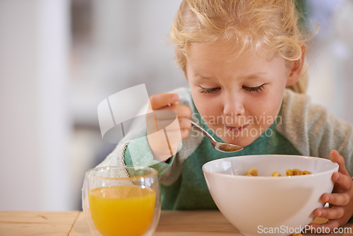 Image of Home, eating and cereal with girl or child, happy morning and nutrition with table. Breakfast, glass or orange juice for vitamins, fibre for toddler and healthy development of growing kid in house