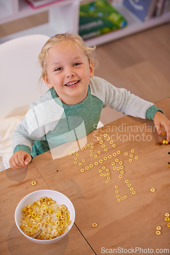 Image of Girl, cereal and play for fun in home, child and morning nutrition with table. Smart, math education with happy vitamins, fibre for toddler and healthy development for growing kid and food in bowl