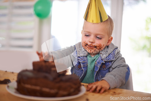 Image of Baby, birthday and eating cake in home, celebration for infant or party. Happy boy, dessert on table or excited cheerful event for growth with special decoration hat or messy face and childhood fun