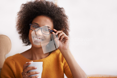 Image of Portrait, smile and glasses on woman in home lounge, coffee and happy for natural lady. Head, confidence and eye wear with curly hair for female person from London, positive in living room or house