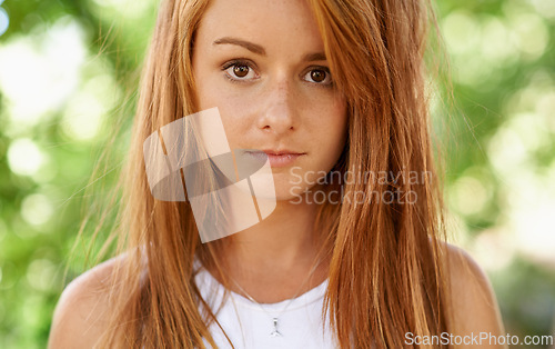 Image of Girl, teenager and portrait in outdoor or garden for comfort, clean and hygiene for natural skin, hair and face. Young person and teen with ginger and freckles for clear and healthy for wellness