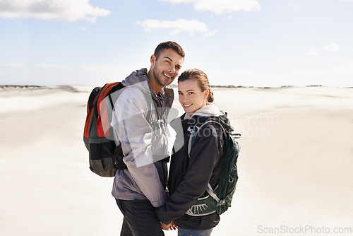 Image of Hiking, sand dunes and couple in portrait for adventure, desert landscape and travel on holiday. Holding hands, explorers and happy nomad people in Sahara terrain, outdoor or dry climate for love