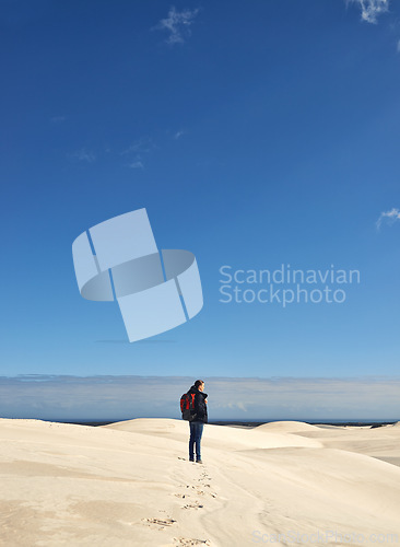 Image of Hiking, sand dunes and woman in nature for adventure, desert landscape and travel for holiday. Mockup space, explorer and nomad person in Sahara terrain, outdoor and dry climate for view or scenery