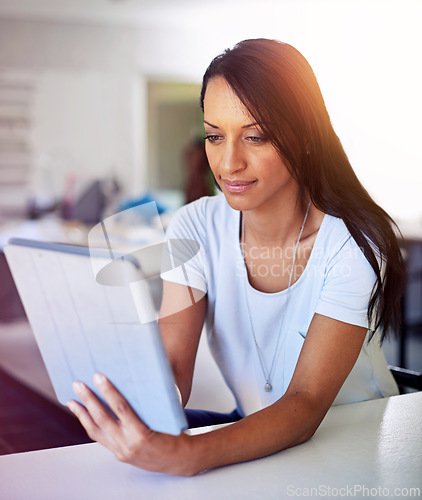 Image of Woman, tablet and planning in office for creative design, e commerce or reading on social media. Young fashion designer, seamstress or tailor with digital technology for clothes production or order