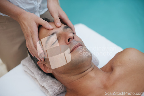 Image of Resort, spa and man relax for massage on table in hotel, calm and care for body in vacation. Holiday, luxury and male person on break for weekend, accommodation and lodge with treatment for skincare