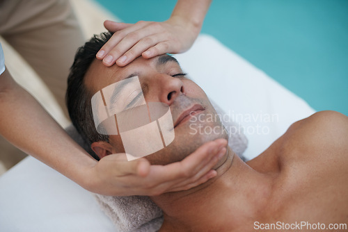 Image of Hotel, spa and man relax for facial massage on table in resort, calm and care for body in vacation. Holiday, luxury and male person on break for weekend and lodge with treatment for skincare
