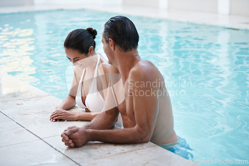 Image of Couple, pool and laugh on vacation together, romance and humor in funny conversation at luxury hotel. Happy people, summer holiday and love or bonding in water, outdoor date and leisure on honeymoon
