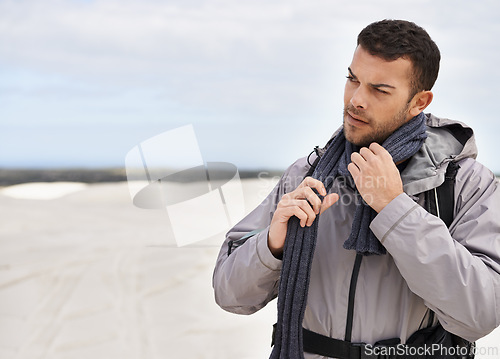 Image of Man, hiking and walking on sand dunes for fitness adventure, desert and extreme sport in arid climate. Athlete, thinking and survival gear for nature exploration, jacket and idea in outdoor in dubai