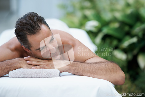 Image of Outdoor, spa and man relax for massage on table in hotel, calm and care for body in vacation. Holiday, luxury and male person on break for weekend, accommodation and lodge with treatment for skincare