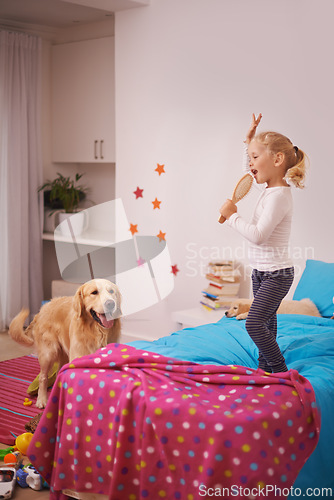 Image of Girl, child and puppy with playing on bed for karaoke, bonding and singing in bedroom of home with brush. Kid, golden retriever and dog for companion, dancing and relax with pet care in apartment