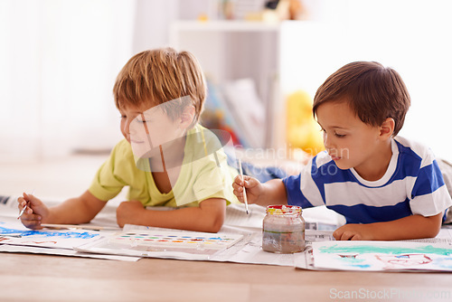 Image of Young children, painting and creative with paint brush on floor or playing room, hobby and drawing together at home. Brothers, motor skills and growth for childhood development with smile for artwork