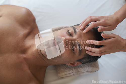 Image of Hands, face massage and top view of man at salon for skincare, peace and calm at luxury resort at table for wellness. Above, therapy and masseuse at spa for head treatment, health and person relax