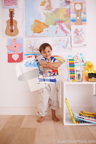 Image of Child, boy and truck in playroom for toy, learning and development with color, picture and book for fun at home. Young kid and smiling for recreation, childhood and growing for innocent and adorable