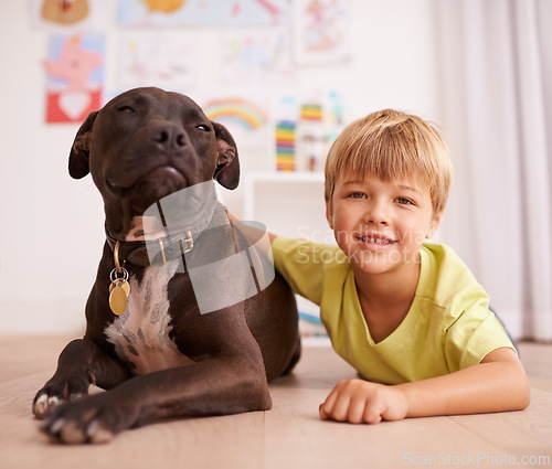 Image of Boy child, dog and portrait, happy with pet and friends in playroom for love and loyalty at home. Youth, kid and bonding with puppy, adoption or foster for animal care and relax on floor with smile