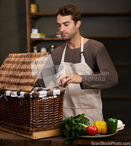 Image of Man, basket and business owner with vegetables or groceries in a bag for cooking or diet in kitchen. Chef packing, shopkeeper and person sorting healthy food dinner or packaging box of ingredients