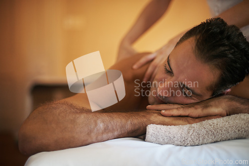 Image of Relax, massage and man at hotel spa for health, wellness and balance with luxury holistic treatment. Self care, vacation and person on bed for muscle therapy, comfort and zen with body pamper service