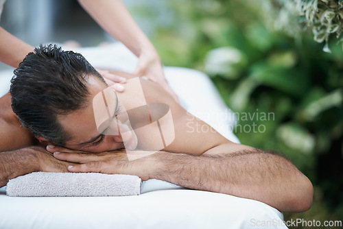 Image of Luxury, spa and man relax for massage on table in hotel, calm and care for body in vacation. Holiday, outdoor and male person on break for weekend, accommodation and lodge with treatment for skincare