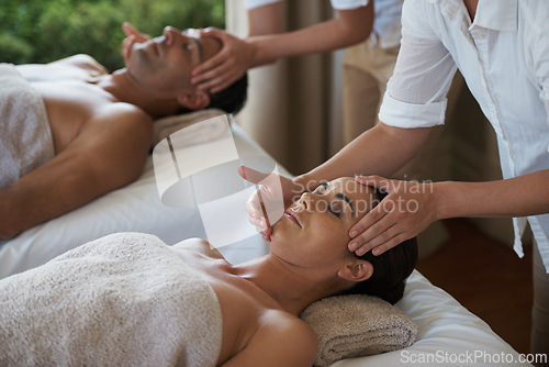 Image of Holiday, head massage and couple relax in spa for care of body with rest on table of retreat for honeymoon. Hotel, man and woman together in resort for health, wellness and luxury for skincare