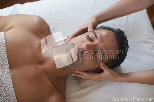 Image of Hands, head massage and top view of man at salon for skincare, peace and calm at luxury resort at table for wellness. Above, therapy and masseuse at spa for face treatment, health and person relax