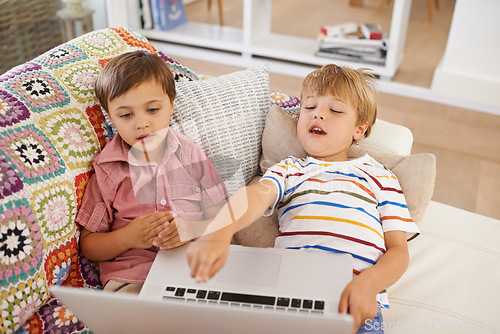 Image of Laptop, kids and siblings on sofa for cartoon, film or streaming movie at home. Computer, learning or boy children in house for google it, search or hand pointing to video, show or Netflix and chill