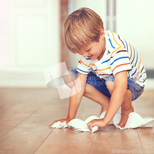 Image of Boy, floor and cleaning in home for mess, spill or household chores for childhood development. Little boy, toilet paper and maintenance in house with hygiene, housework and learning responsibility