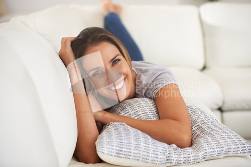 Image of Portrait, woman and smile with lying on sofa in living room, break and leisure for wellbeing and satisfied. Female person, home and holiday with pillow on day off to relax, chill and calm on couch
