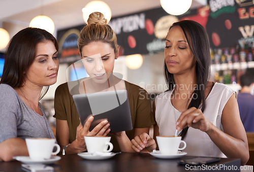 Image of Woman, together and read at coffee shop with tablet for online menu or restaurant review, diversity and relax for leisure. Female friends, digital technology and internet to search or browse website.