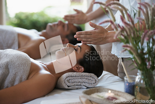 Image of Hands, head massage and couple in spa to relax on bed for luxury pamper treatment together in hotel. Beauty, facial or zen woman with man at resort or salon for natural healing benefits or skincare