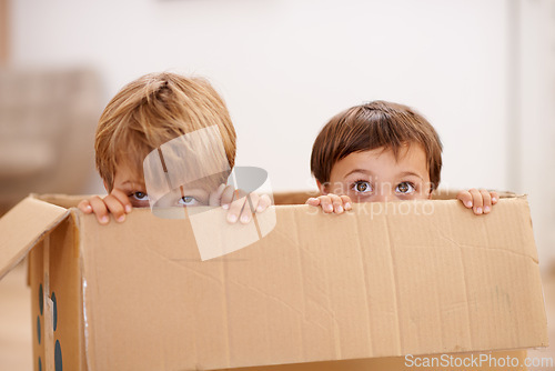 Image of Box, children and eyes of siblings playing in a house with fun, bonding and hide and seek games. Cardboard, learning and curious kid brothers in a living room with fantasy, imagine or hiding at home