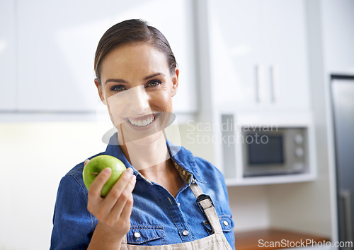 Image of Happy woman, portrait and kitchen with apple for diet, natural nutrition or healthy eating at home. Face of female person with smile and organic green fruit for vitamins, fiber or health and wellness