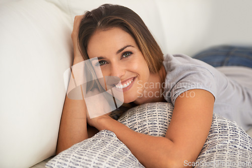 Image of Woman, portrait and relax on couch in living room, calm and comfort with positive mood for leisure. Rest, lying down with pillow and smile for stress relief, break on day off or weekend at home