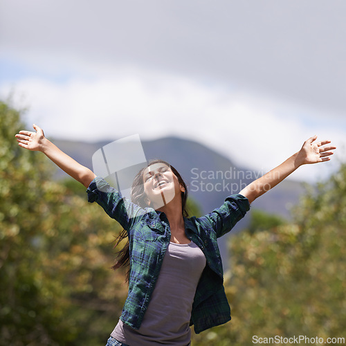 Image of Freedom, smile and hands raised with young woman in garden of home for enthusiasm or inspiration. Nature, relax and wellness with happy person outdoor at park in summer for energy or excitement