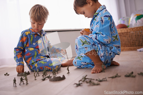 Image of Boys, playing and kids in pajamas with toys for fun with action figures, car or games. Brothers, child development and young children bonding together in playroom for learning at family home.