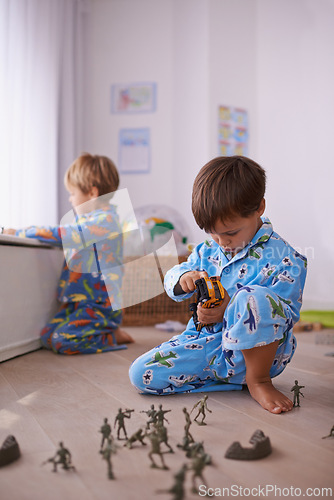 Image of Boys, toys and young children in pajamas playing for fun with action figures, car or games. Brothers, child development and young kids bonding together in playroom for learning at family home.