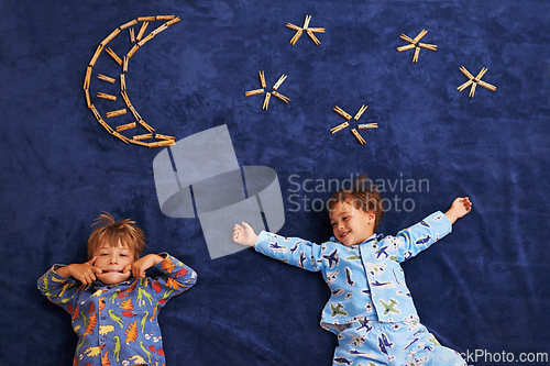 Image of Smile, playing and children with funny face for night, moon and stars carpet. Happiness, above view and siblings for playful facial expression, growth and childhood development in bedroom floor