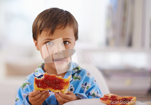 Image of Portait, food, and breakfast for young boy eating, bread and pyjamas in home for nutrition. Children, childhood and development with toast for health, jam and snack or wellness for kid male person
