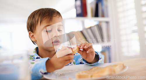 Image of Food, breakfast and boy eating for nutrition, toast and home dinning room in morning. Pyjamas, children and hungry with bread for health and development, jam and snack or wellness for toddler