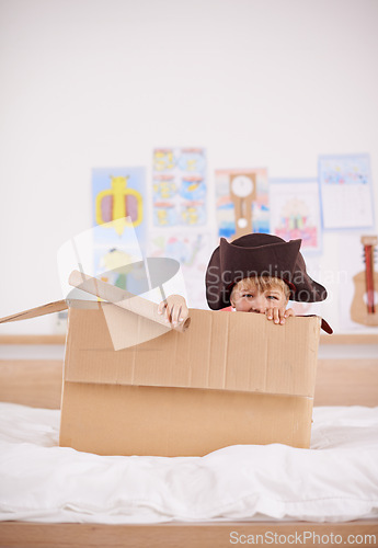 Image of Home, portrait or costume as pirate to play in boat boxes or fantasy in bedroom or house. Kid hiding, child captain or boy in an adventure game with cardboard or monocular telescope to sail on ship