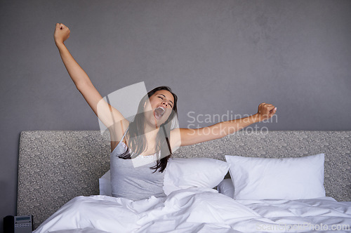 Image of Woman, bedroom and wake up in morning with yawn for routine or fatigue, stretching and sleepy after rest. Female person, home and awake after sleep for wellness, energy and comfort for mental health.