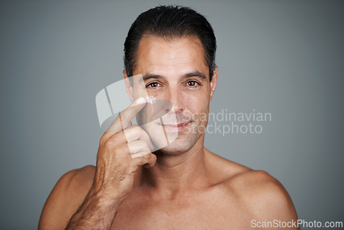 Image of Man, smile and studio with face cream, mature male person with skincare and moisturizing lotion. Dermatology, sunblock or anti aging product for facial treatment, natural grooming for wellness