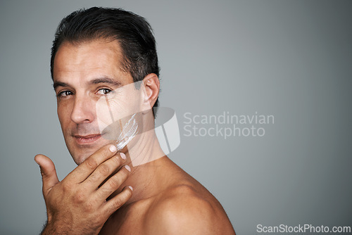 Image of Man, smile and studio with face cream, mature male person with skincare and moisturizing lotion. Dermatology, anti aging product with mockup for facial treatment, natural grooming for wellness