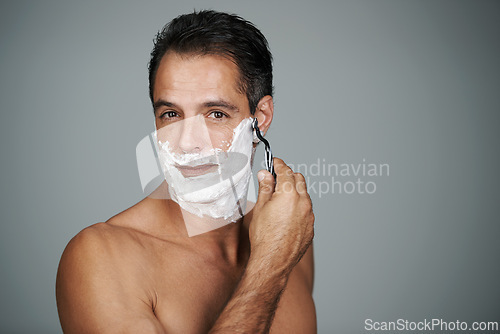 Image of Shaving cream, portrait and man in studio with razor for epilation or hair removal treatment. Skin, natural and face of mature person with shaver for facial dermatology routine by gray background.